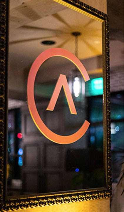 The ADCOLOR mark applied to a gilt-framed mirror in the venue.