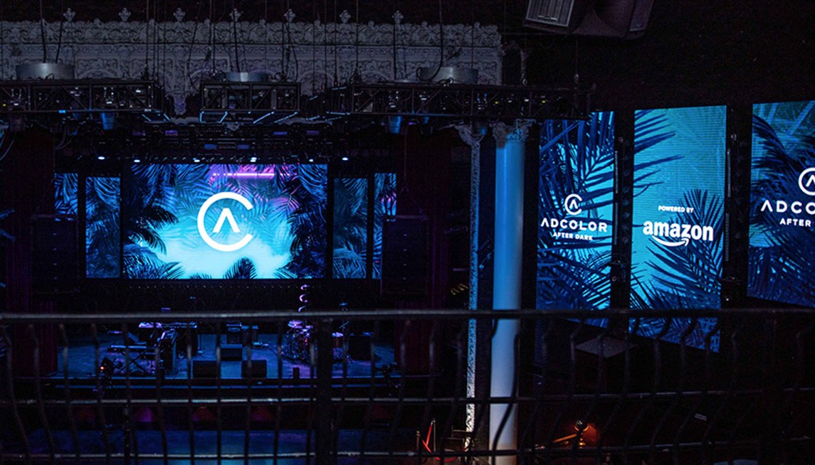 ADCOLOR After Dark from the balcony: the stage LED wall carrying the mark, with sponsor panels running along the right.