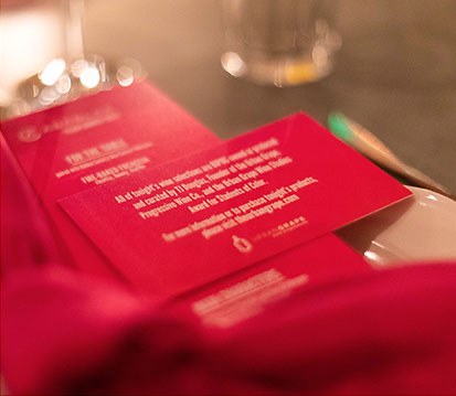 Printed table cards in the campaign's pink, stacked on a table at the awards dinner.