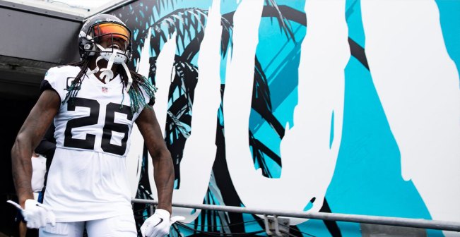 A player stepping out of the tunnel in front of the painted Duuuval wall and its palm textures.