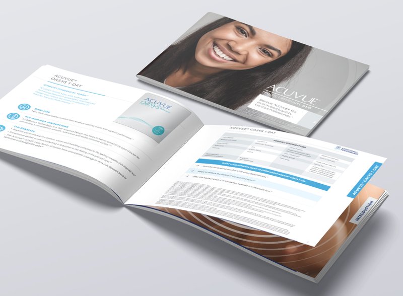 The printed ACUVUE product brochure open on a desk beside its closed cover.