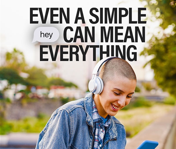 Campaign post reading Even a simple hey can mean everything, with hey set in a speech bubble, over someone smiling at their phone.